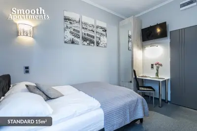 a bedroom with a bed and a desk with a computer at SMOOTH Elegant Apartments KRAKÓW Old Town in Kraków