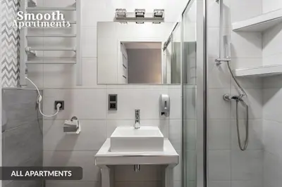 a bathroom with a sink and a shower with a mirror at SMOOTH Elegant Apartments KRAKÓW Old Town in Kraków