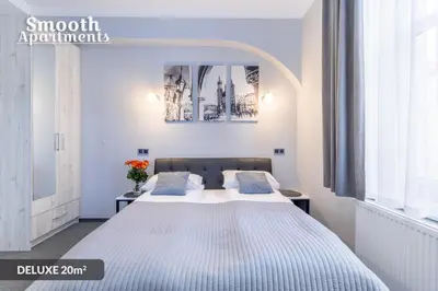 a bedroom with a large white bed with blue pillows at SMOOTH Elegant Apartments KRAKÓW Old Town in Kraków