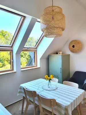 a dining room with a table and some windows at Slow Life Rabka in Rabka