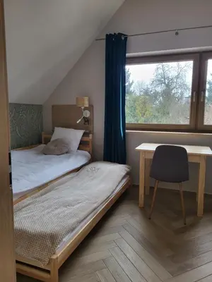 a bedroom with a bed and a desk and a window at Slow Life Rabka in Rabka
