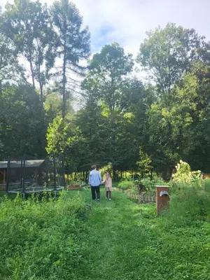 a man and woman walking down a path in a field at Slow Life Rabka in Rabka
