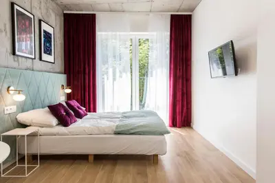 a room with a bed and a table and a kitchen at Piedmont House in Kraków