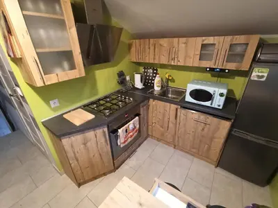 a small kitchen with wooden cabinets and a black refrigerator at Feel like in Heaven in Bachowice