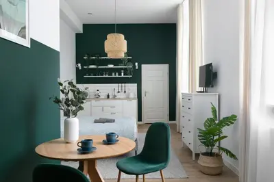 a kitchen with green walls and a table and chairs at Charming Apartment, Wawel & Old Town Krakow in Kraków