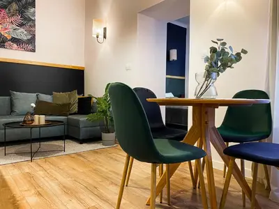 a living room with a table and green chairs at Charming Apartment, Wawel & Old Town Krakow in Kraków