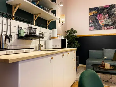 a kitchen with white cabinets and a green chair at Charming Apartment, Wawel & Old Town Krakow in Kraków