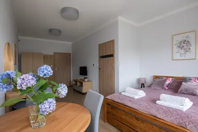 a bedroom with a bed and a table with a vase of flowers at Dębowy Zakątek - SPOKOJNY, KOMFORTOWY WYPOCZYNEK W OKOLICY KRAKOWA in Radziszów