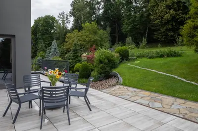 a patio with chairs and a table with flowers at Dębowy Zakątek - SPOKOJNY, KOMFORTOWY WYPOCZYNEK W OKOLICY KRAKOWA in Radziszów