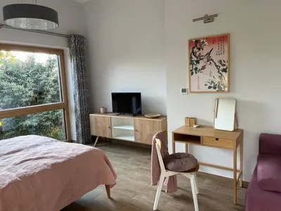 a bedroom with a bed and a desk with a television at Dębowy Zakątek - SPOKOJNY, KOMFORTOWY WYPOCZYNEK W OKOLICY KRAKOWA in Radziszów