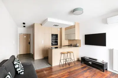 a living room with a couch and a kitchen at Apartamenty Platinex 4 in Kraków