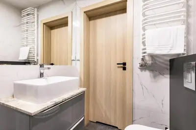 a bathroom with a white sink and a toilet at Apartamenty Platinex 4 in Kraków