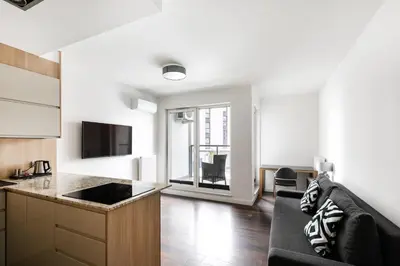 a living room with a couch and a kitchen at Apartamenty Platinex 4 in Kraków