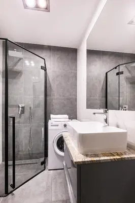 a bathroom with a sink and a washing machine at Apartamenty Platinex 4 in Kraków