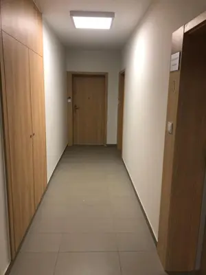 an empty hallway with wooden doors and a tile floor at Apartamenty Platinex 4 in Kraków