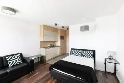 a bedroom with a bed and a black couch at Apartamenty Platinex 5 in Kraków