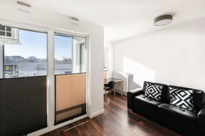 a living room with a couch and a large window at Apartamenty Platinex 5 in Kraków