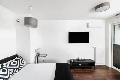a bedroom with a bed and a tv on a wall at Apartamenty Platinex 5 in Kraków