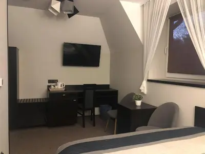 a bedroom with a desk and a television on the wall at Zajazd Podzamcze in Olkusz
