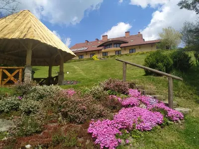 a gazebo and flowers in front of a house at ZAGÓRZANKA Pensjonat Rehabilitacyjno-Rekreacyjny SiS Dziadkowiec - Spółka Jawna in Mszana Dolna