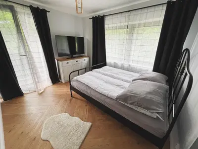 a bedroom with a bed and a flat screen tv at Apartamenty Pod Kątami in Kamienica