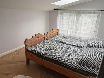 a bedroom with a wooden bed with a window at Apartamenty Pod Kątami in Kamienica