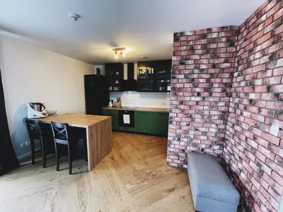 a brick wall in a kitchen with a table and chairs at Apartamenty Pod Kątami in Kamienica