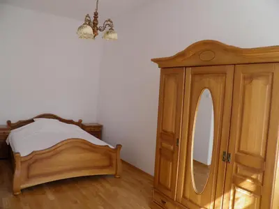 a bedroom with a wooden bed and a mirror at Apartment Świetego Tomasza in Kraków