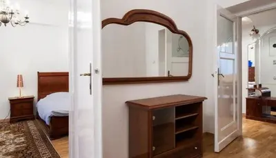 a bedroom with a bed and a mirror on the wall at Apartment Świetego Tomasza in Kraków
