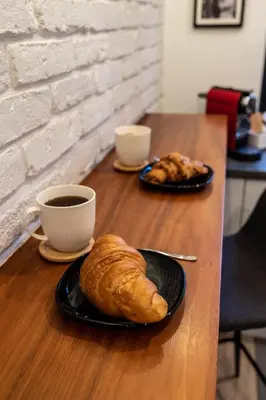a table with a plate of bread and a cup of coffee at Smart Executive in Kraków