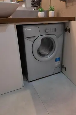 a washing machine in a kitchen under a counter at Smart Executive in Kraków