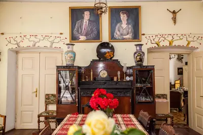a dining room with a table with red flowers on it at Dwór w Odonowie in Odonów
