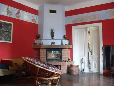 a living room with red walls and a fireplace at Dwór w Odonowie in Odonów