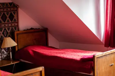 a bedroom with a red bed in a attic at Dwór w Odonowie in Odonów