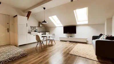 a living room with a table and a kitchen with windows at Zamkowa 9 Apartment with a view on Wawel Castle by Homeprime in Kraków