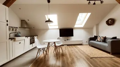 a kitchen and living room with a table and a couch at Zamkowa 9 Apartment with a view on Wawel Castle by Homeprime in Kraków