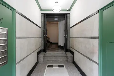 a corridor of a hallway with green doors and stairs at Partnerapart Rakowicka 14 in Kraków