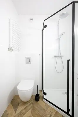 a bathroom with a glass shower with a toilet at Partnerapart Rakowicka 14 in Kraków