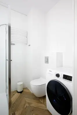 a white bathroom with a toilet and a tv at Partnerapart Rakowicka 14 in Kraków