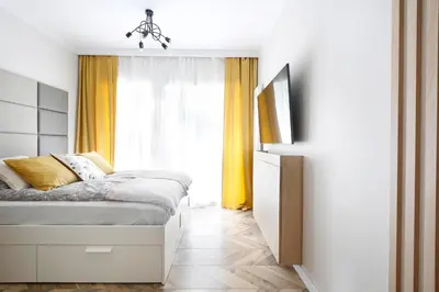 a bedroom with a bed and a large window at Partnerapart Rakowicka 14 in Kraków