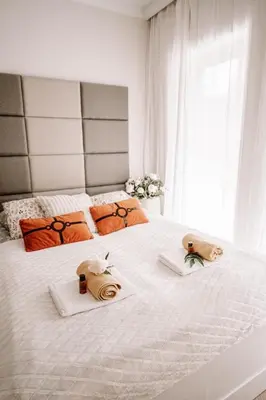 a bedroom with a white bed with two towels on it at Partnerapart Rakowicka 14 in Kraków