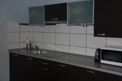 a kitchen with a sink and a microwave at 999 Aparthostel in Kraków