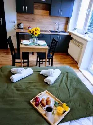 a table with a tray of food on a bed at Orange Apartament in Wadowice
