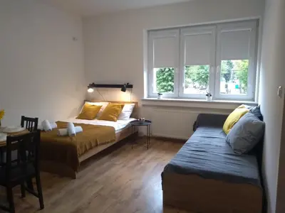a bedroom with a bed and a window at Orange Apartament in Wadowice
