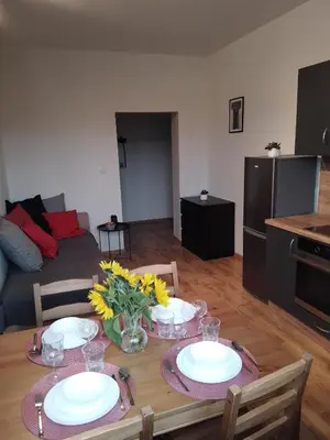 a living room with a table with plates and flowers on it at Orange Apartament in Wadowice