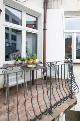 a balcony with two tables and two windows at Discover Krakow Apartments - 3 Rakowicka St - Classic Apartments near Main Station - Netflix in Kraków
