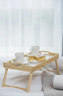 a wooden coffee table with two cups and food on it at W Parku Lotników Apartments Tauron Arena by Noclegi Renters in Kraków