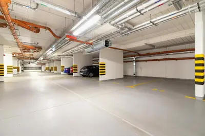 an empty parking garage with a car parked in it at W Parku Lotników Apartments Tauron Arena by Noclegi Renters in Kraków