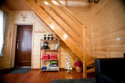 an attic room with a wooden staircase with a wooden door at Babia Chata in Zawoja