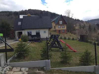 a yard with a playground in front of a house at Babia Chata in Zawoja